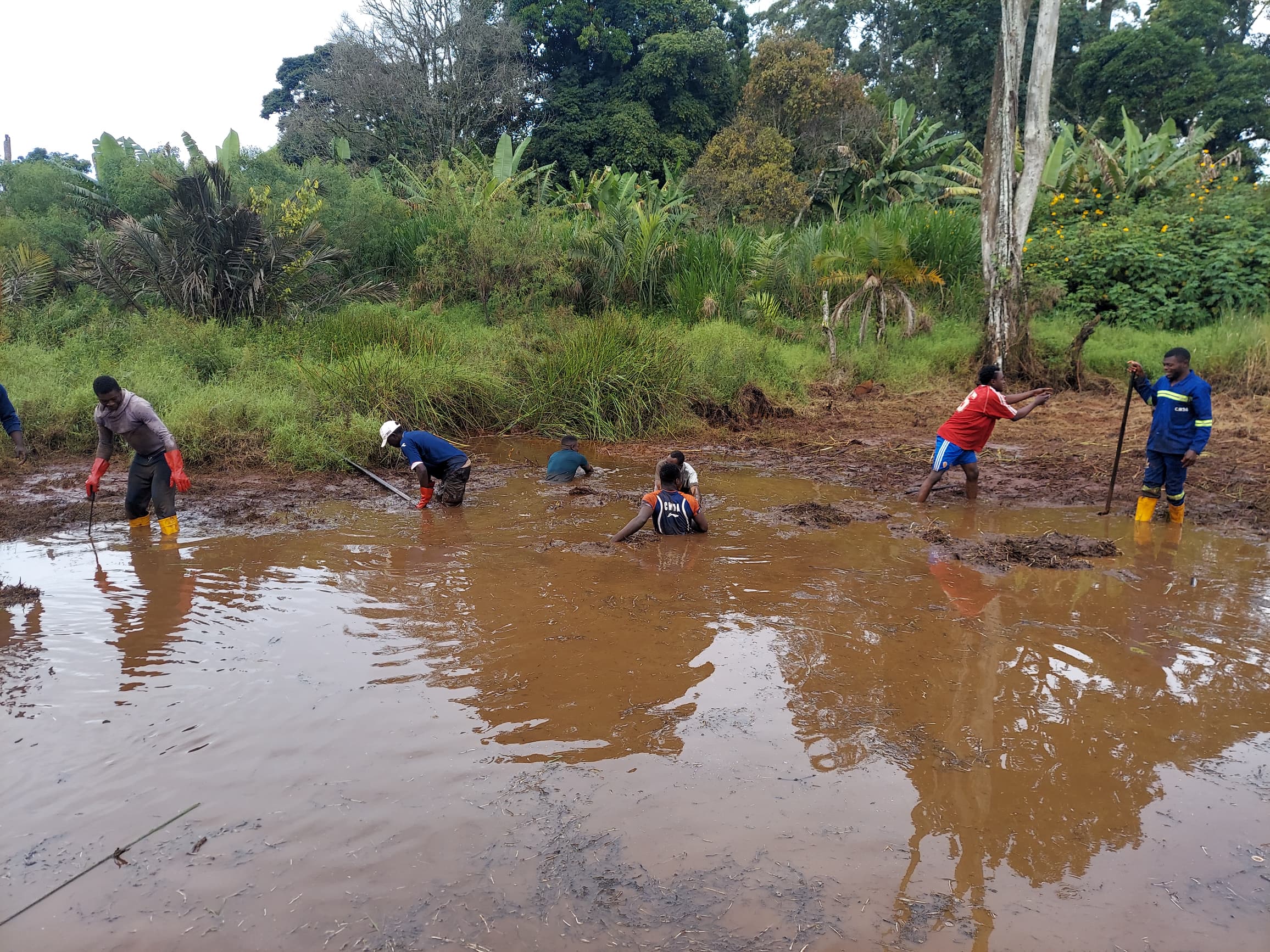 Les jeunes nettoyent la rivière de Temmekouang qui abrite l'un des lieux sacrés les plus puissant du village